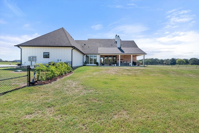 rear view of house with a yard and a patio area