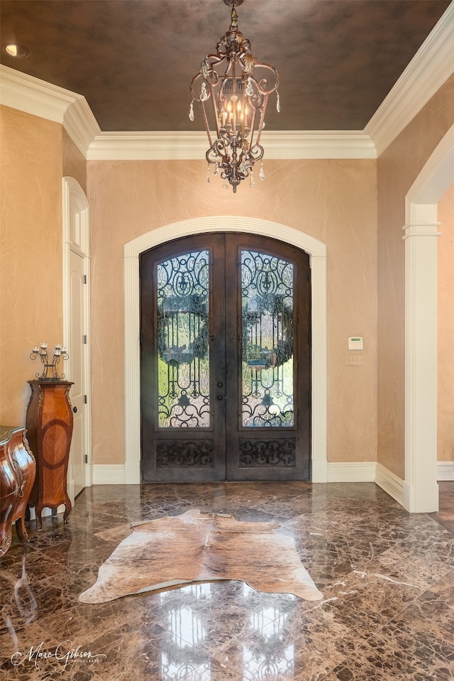 entryway featuring french doors, a notable chandelier, and crown molding