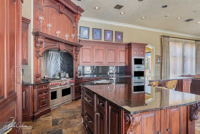 kitchen featuring tasteful backsplash, a kitchen island with sink, sink, crown molding, and stainless steel appliances