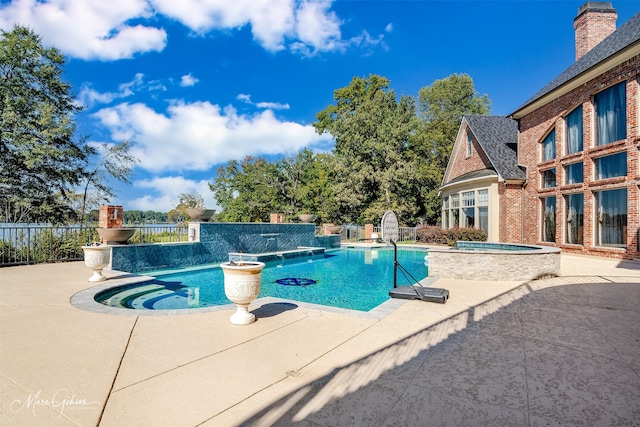 view of pool with a patio area, pool water feature, and an in ground hot tub