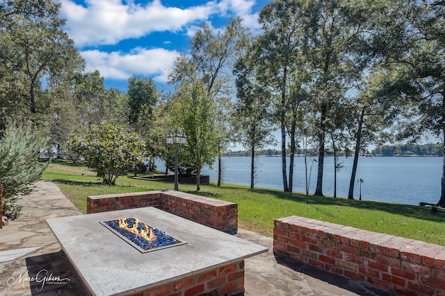 view of patio / terrace with a fire pit and a water view