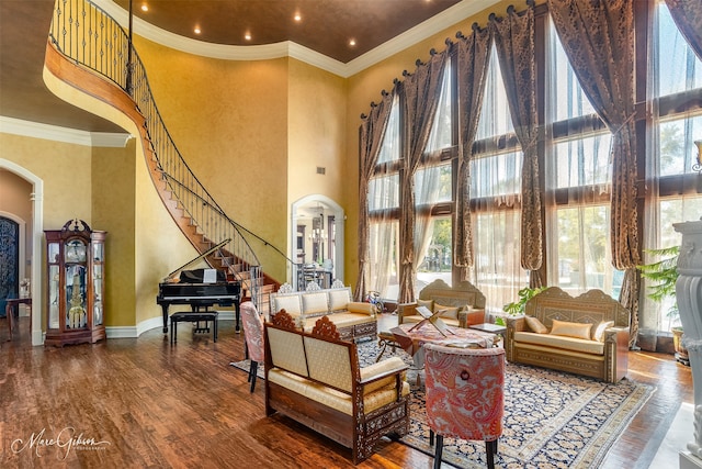 sitting room featuring ornamental molding, hardwood / wood-style flooring, and a towering ceiling