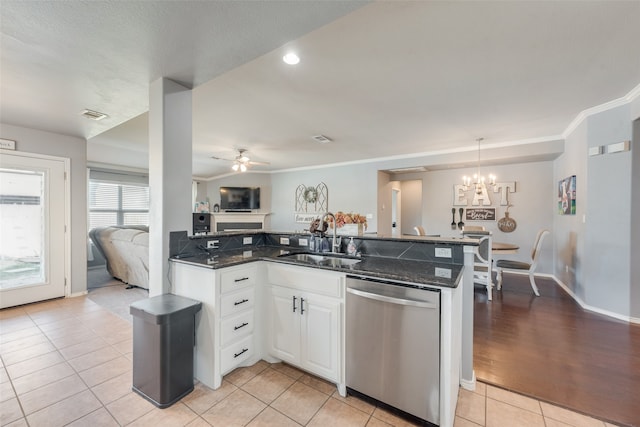 kitchen featuring dark stone countertops, white cabinets, dishwasher, decorative light fixtures, and sink