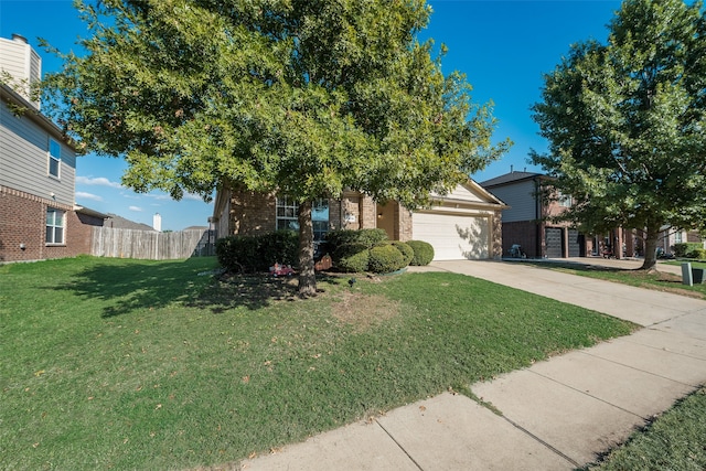 view of property hidden behind natural elements with a garage and a front lawn