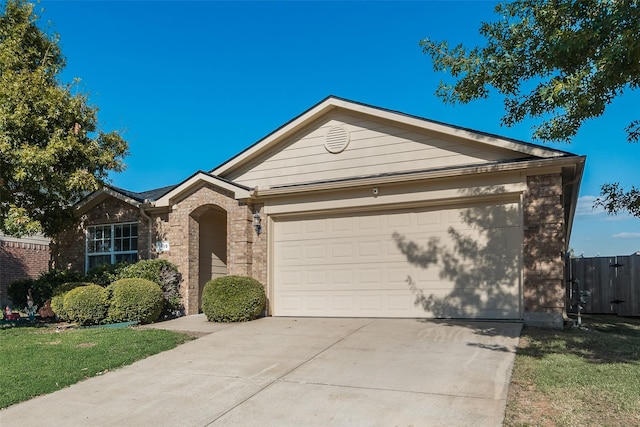 ranch-style home with driveway, an attached garage, fence, and brick siding