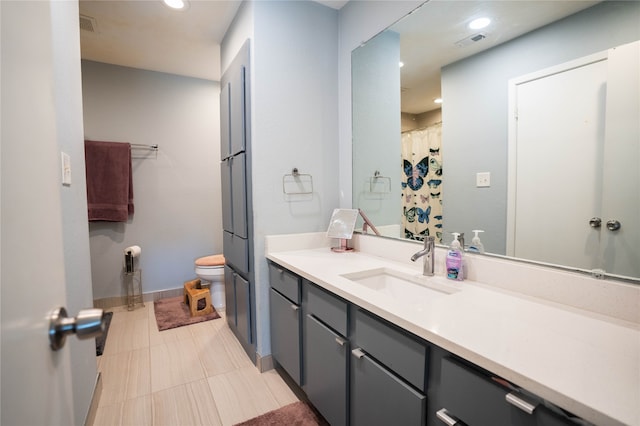 bathroom featuring tile patterned flooring, vanity, and toilet