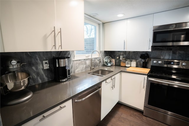 kitchen featuring sink, dark wood-type flooring, stainless steel appliances, and white cabinets