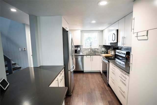 kitchen featuring tasteful backsplash, white cabinets, stainless steel appliances, dark hardwood / wood-style floors, and sink