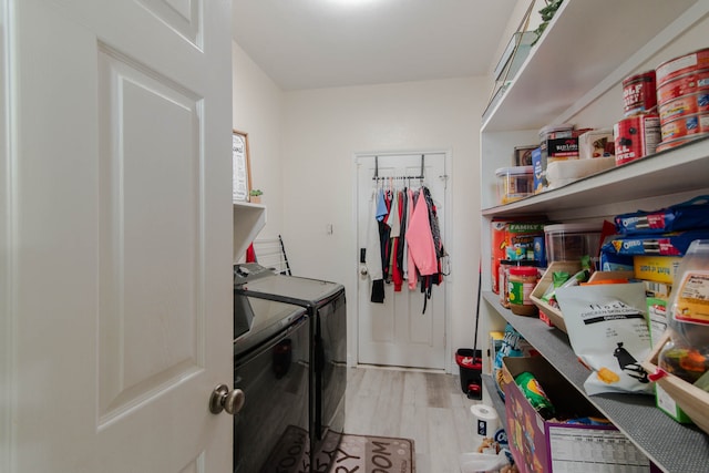 clothes washing area featuring washer and clothes dryer and light hardwood / wood-style floors