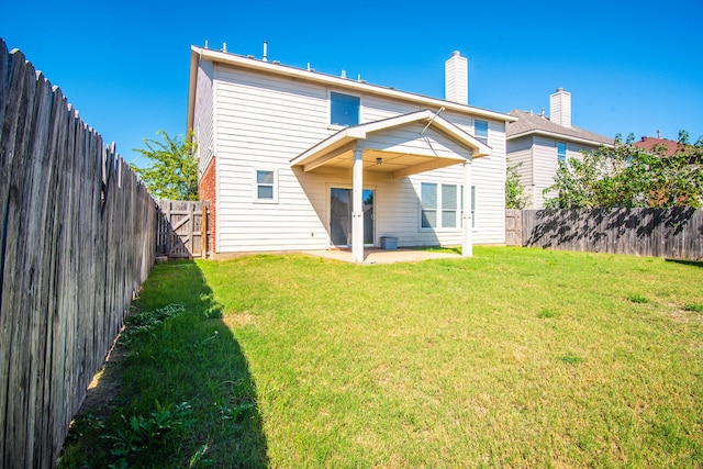 back of house featuring a lawn and a patio area