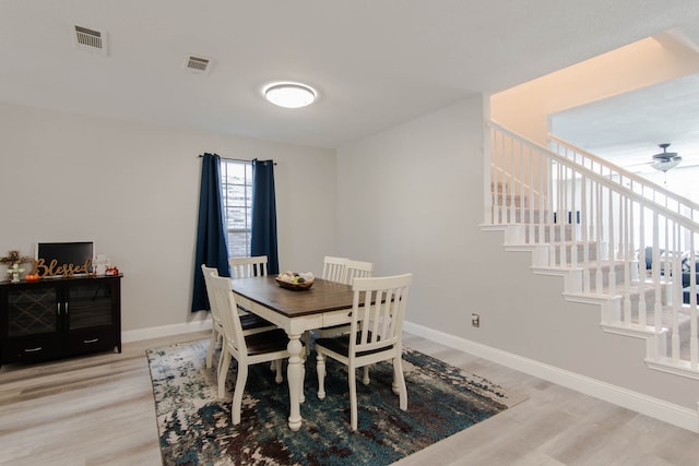 dining space with ceiling fan and light wood-type flooring