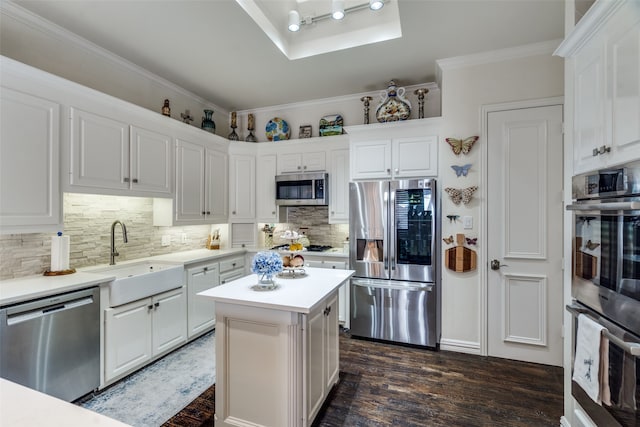 kitchen featuring dark wood-type flooring, sink, white cabinetry, a kitchen island, and appliances with stainless steel finishes