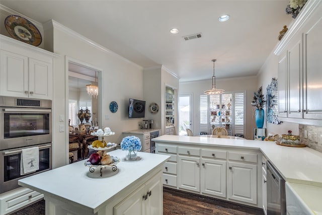 kitchen with tasteful backsplash, white cabinets, kitchen peninsula, stainless steel appliances, and crown molding