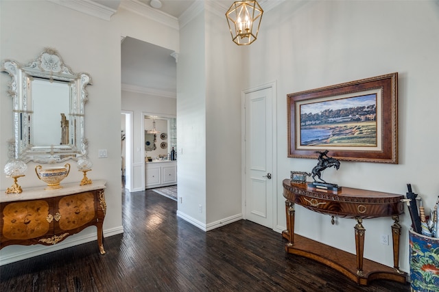 foyer featuring ornamental molding, dark hardwood / wood-style floors, and a notable chandelier