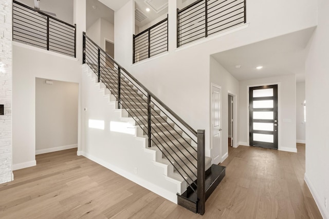 entryway with light hardwood / wood-style flooring and a high ceiling