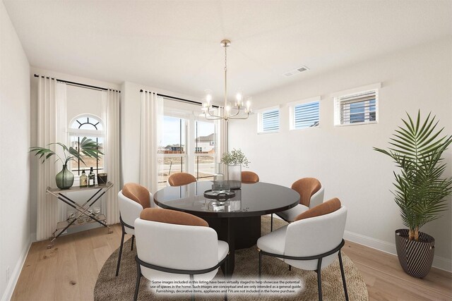 dining area with an inviting chandelier and light hardwood / wood-style floors