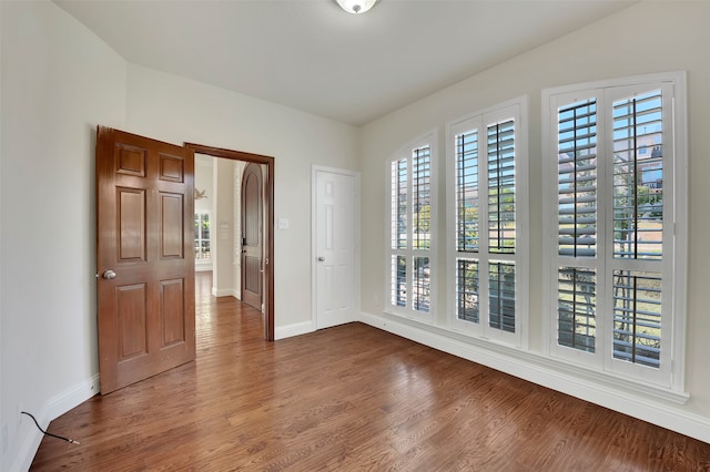 unfurnished room with wood-type flooring