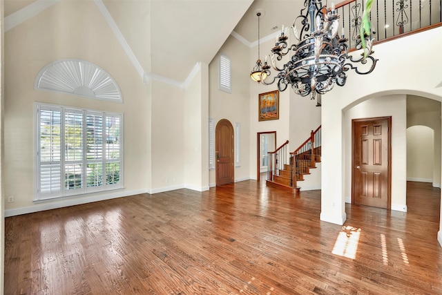 entryway with an inviting chandelier, hardwood / wood-style flooring, and high vaulted ceiling