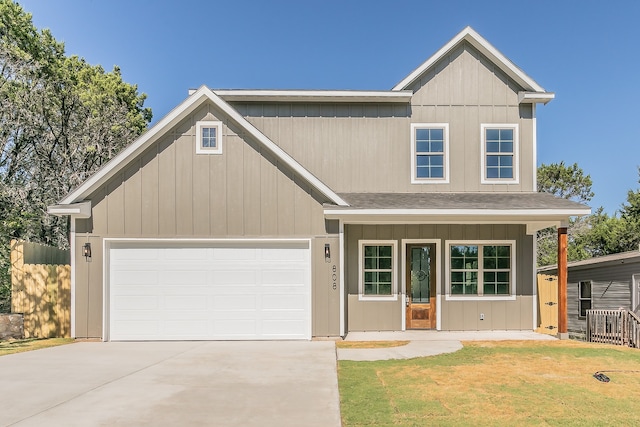 view of front of home with a front yard, a porch, and a garage