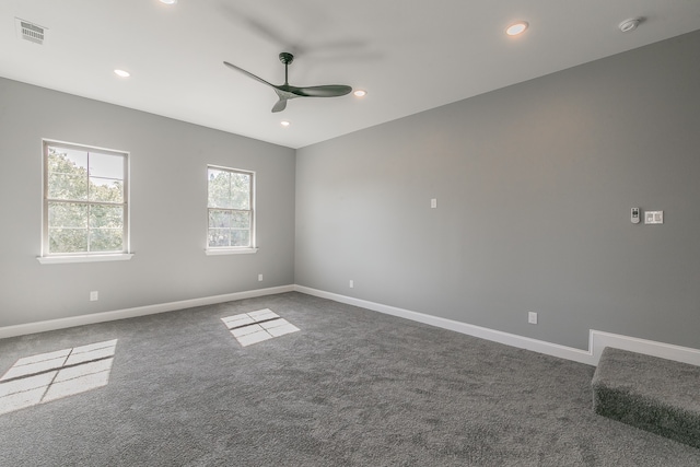 spare room featuring dark carpet and ceiling fan