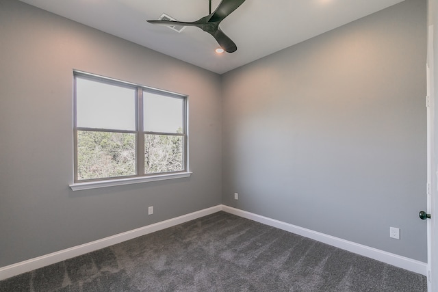 spare room featuring dark carpet and ceiling fan