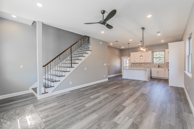 unfurnished living room with hardwood / wood-style floors and ceiling fan