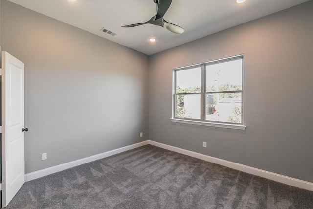 spare room with ceiling fan and dark carpet