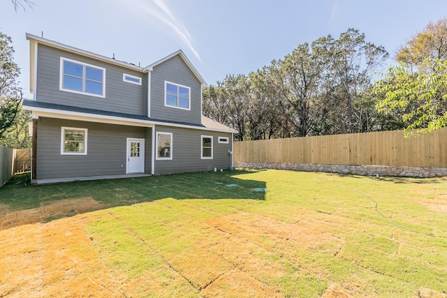 rear view of house featuring a lawn