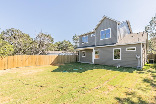 back of property featuring a lawn and central air condition unit