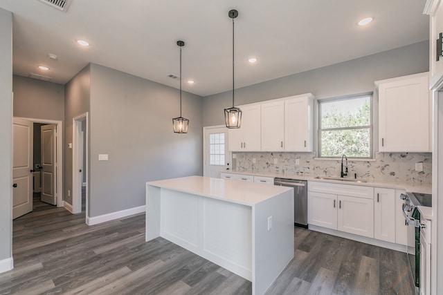 kitchen with range with electric stovetop, a kitchen island, white cabinetry, and sink