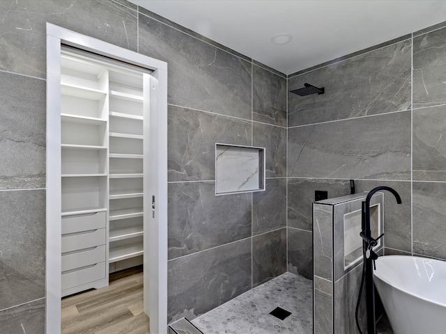 bathroom with shower with separate bathtub, hardwood / wood-style flooring, and tile walls