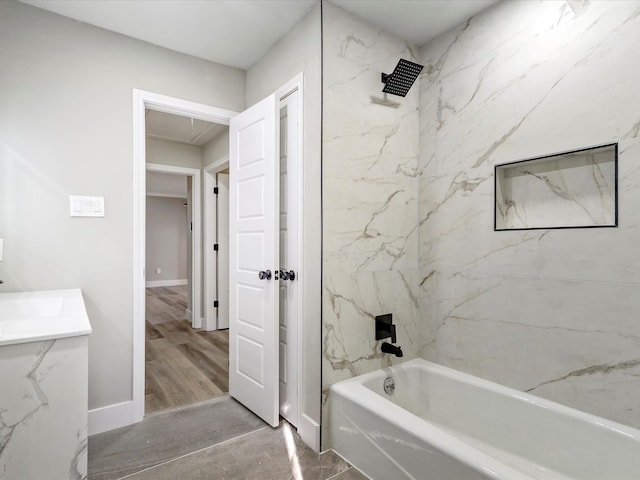 bathroom featuring vanity, hardwood / wood-style flooring, and tiled shower / bath