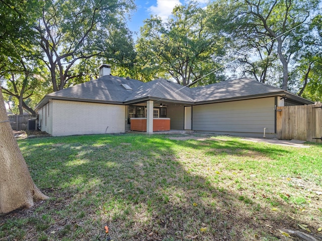 view of front of house with a front yard, cooling unit, and a patio area