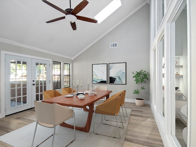 dining room with light hardwood / wood-style floors, high vaulted ceiling, crown molding, ceiling fan, and french doors