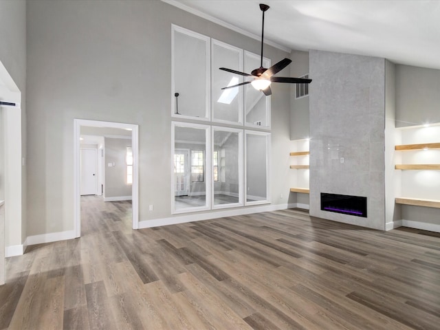 unfurnished living room with high vaulted ceiling, ceiling fan, hardwood / wood-style flooring, and a fireplace