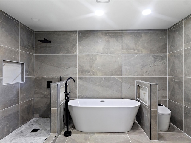 bathroom featuring shower with separate bathtub, tile walls, and toilet