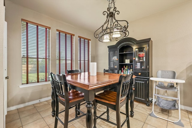 tiled dining room with a notable chandelier