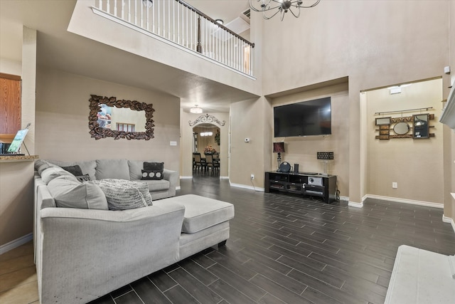 living room featuring a notable chandelier, a high ceiling, and dark hardwood / wood-style flooring