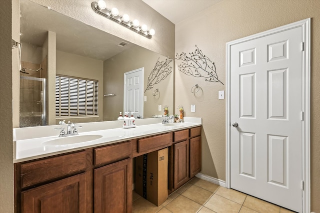 bathroom with walk in shower, vanity, and tile patterned floors