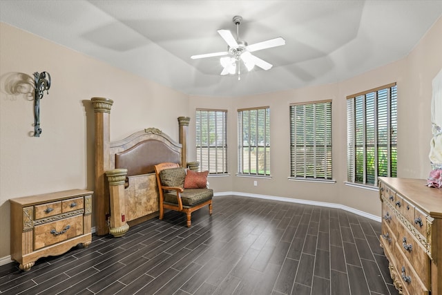 living area with ceiling fan, dark wood-type flooring, and plenty of natural light