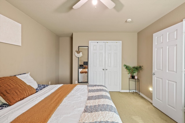 carpeted bedroom featuring ceiling fan and a closet