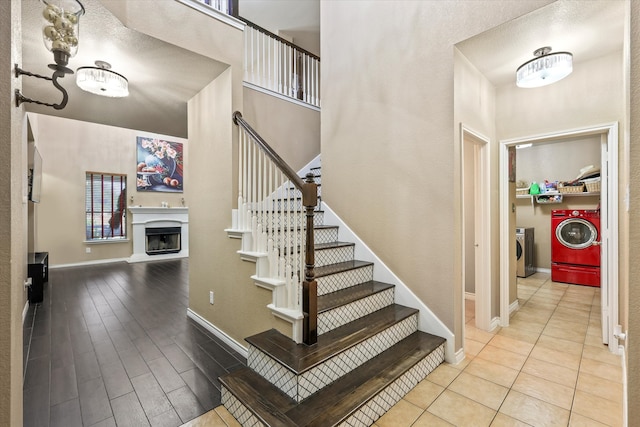 stairs with wood-type flooring and separate washer and dryer