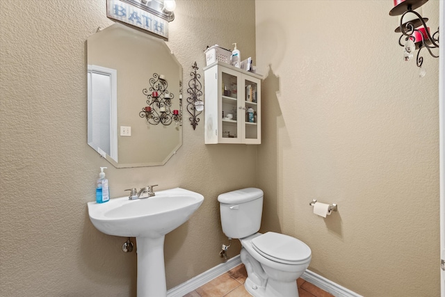 bathroom featuring sink, tile patterned flooring, and toilet