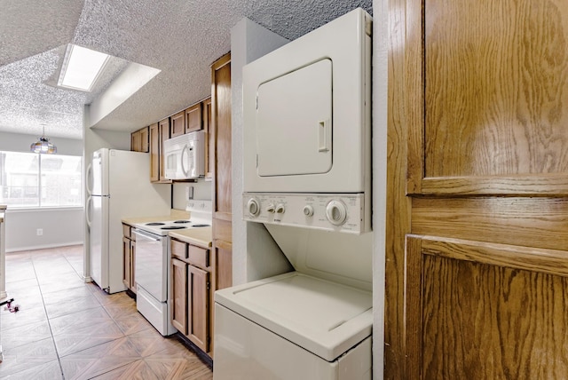 washroom featuring a textured ceiling, a skylight, and stacked washing maching and dryer