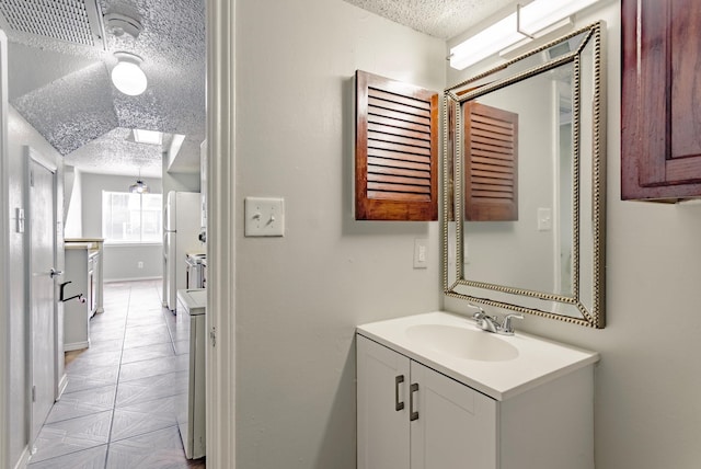 bathroom with a textured ceiling, a skylight, and vanity