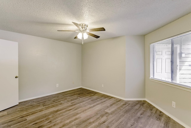 spare room featuring light hardwood / wood-style floors, ceiling fan, and a textured ceiling