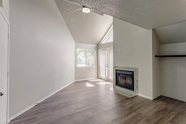 unfurnished living room with hardwood / wood-style flooring, a fireplace, vaulted ceiling, and a textured ceiling