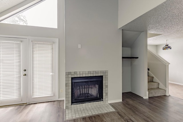 unfurnished living room featuring a textured ceiling, a fireplace, and dark hardwood / wood-style floors