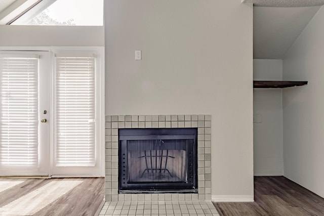 room details with a tile fireplace and hardwood / wood-style floors