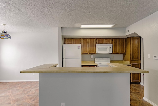 kitchen with kitchen peninsula, white appliances, a textured ceiling, and light parquet flooring